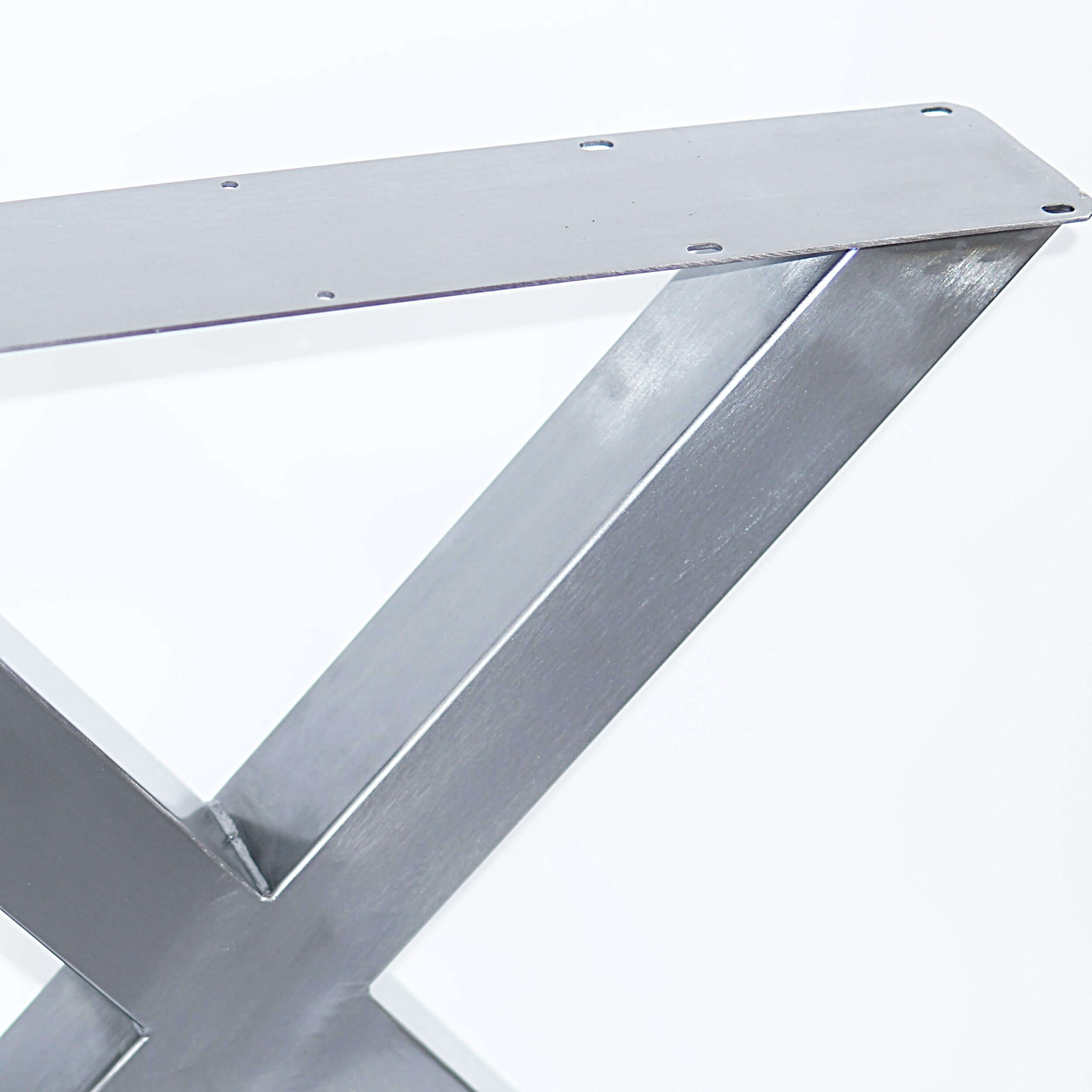 Silver bench X-leg support with wide top plate and drilled mounting holes.