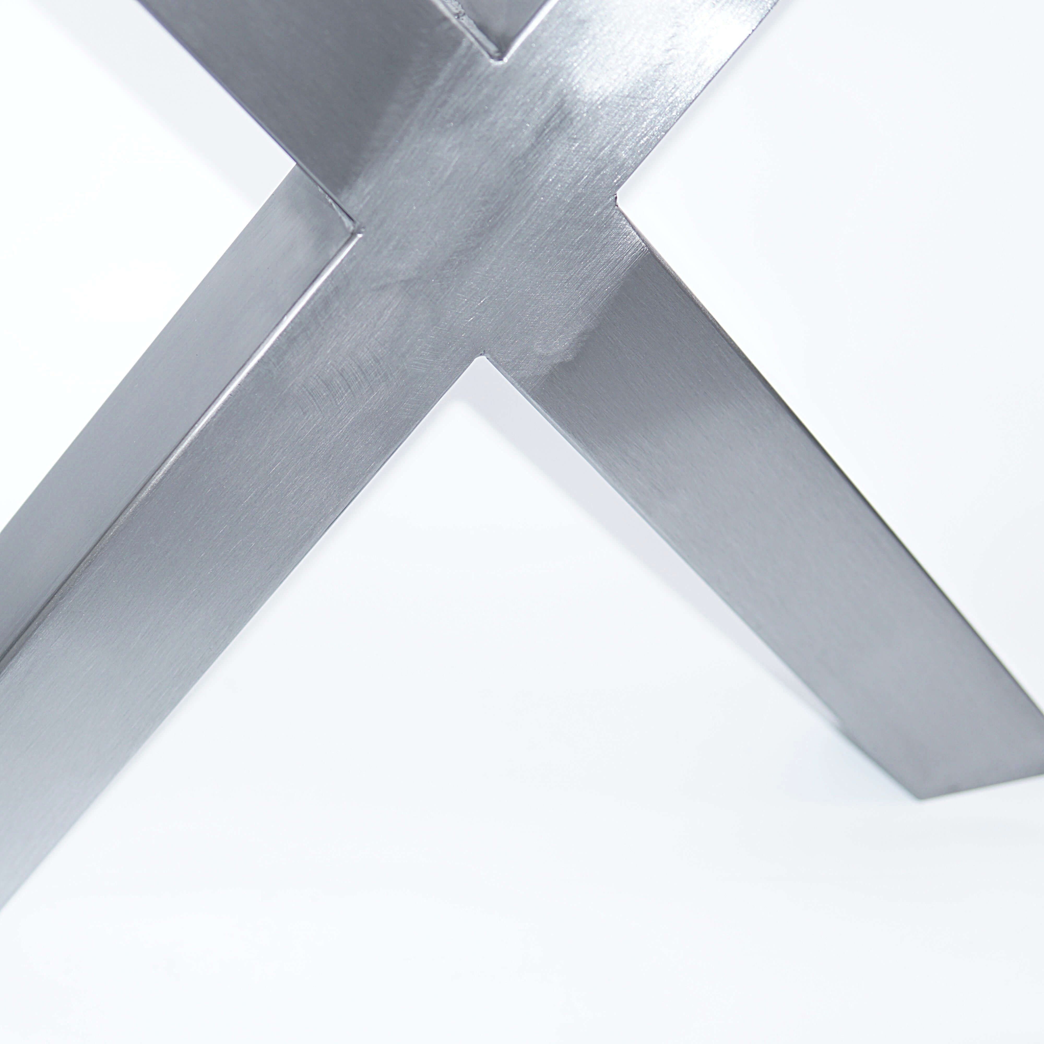 Close-up of silver bench X-leg cross brace with welded joints and mounting hardware.