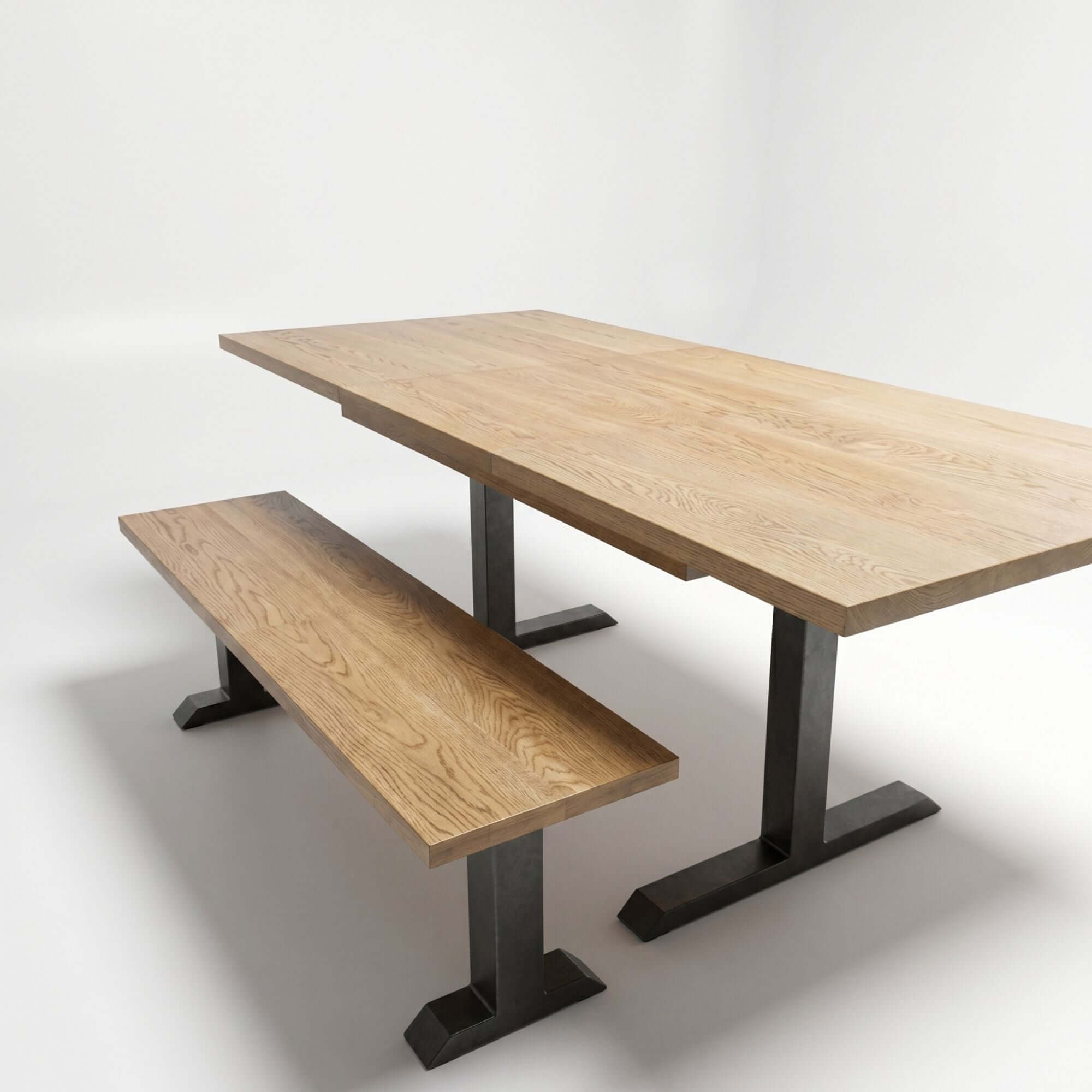 Dining table setup with black powder-coated T-shaped legs under light wood top