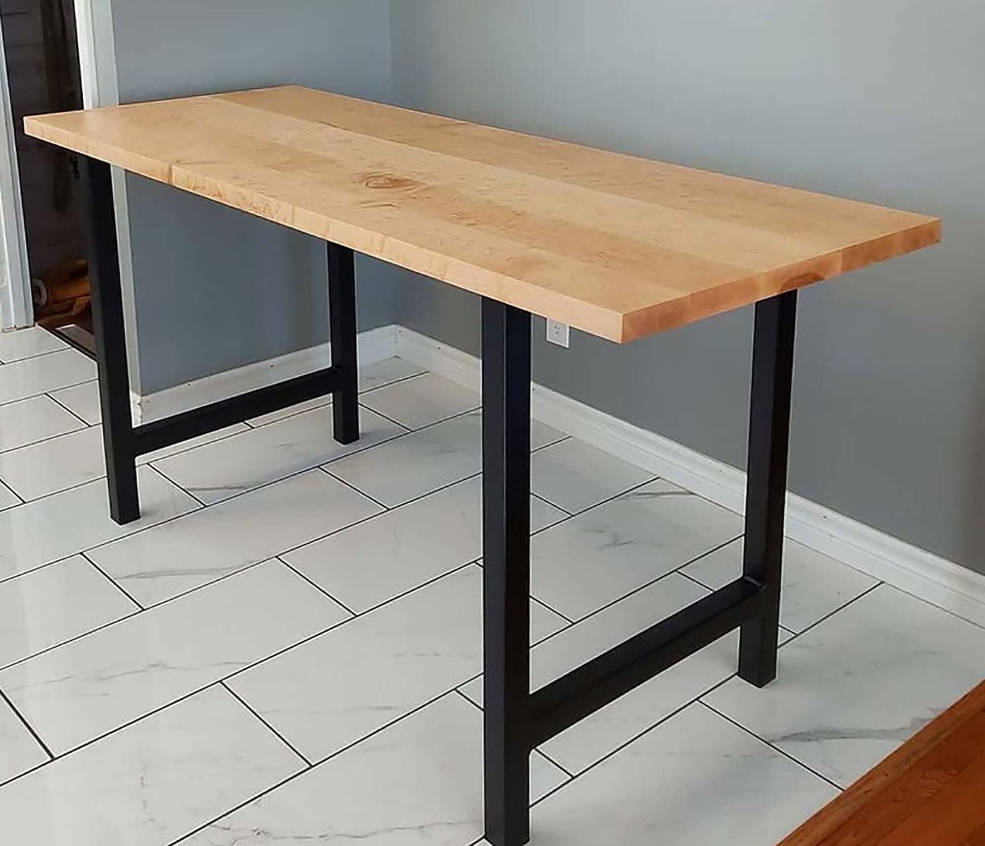 Rectangular dining table with light wood top and dark H-style legs
