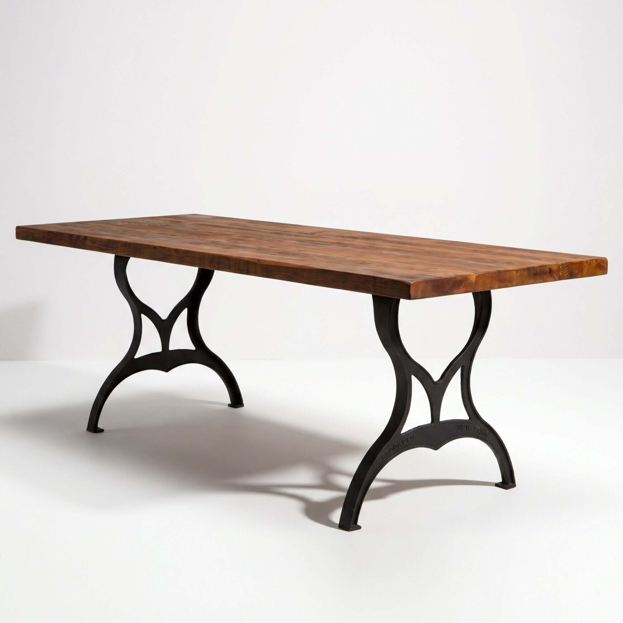 Cast iron dining table legs with matte black finish, supporting a wood tabletop