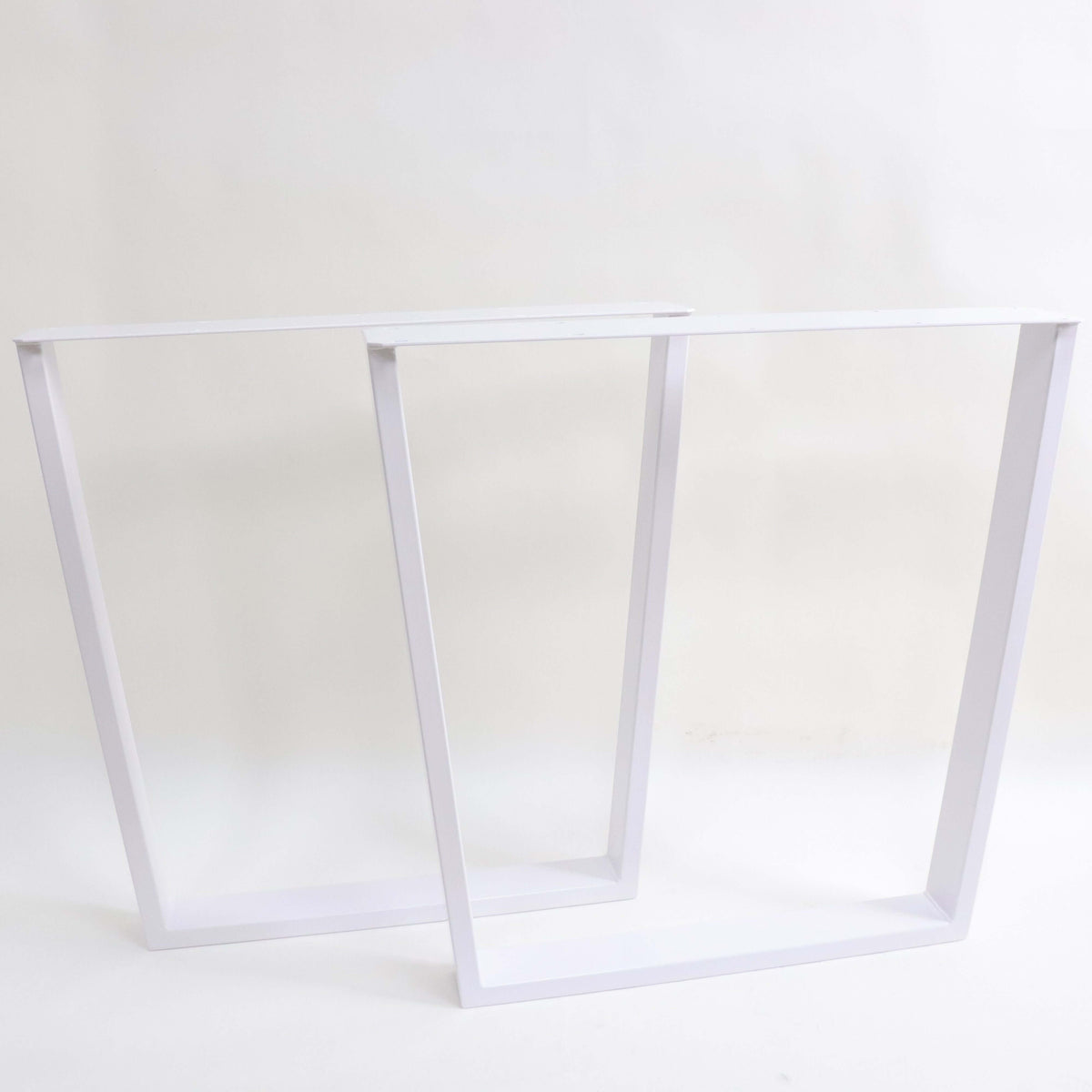 White trapezoid dining table leg frame with wide top, open rectangular support