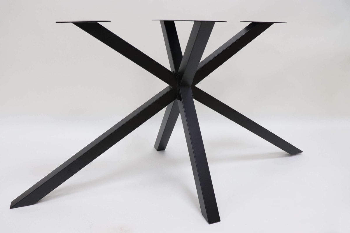 Spider dining table base at a three-quarter angle, dark metal legs with top plate.