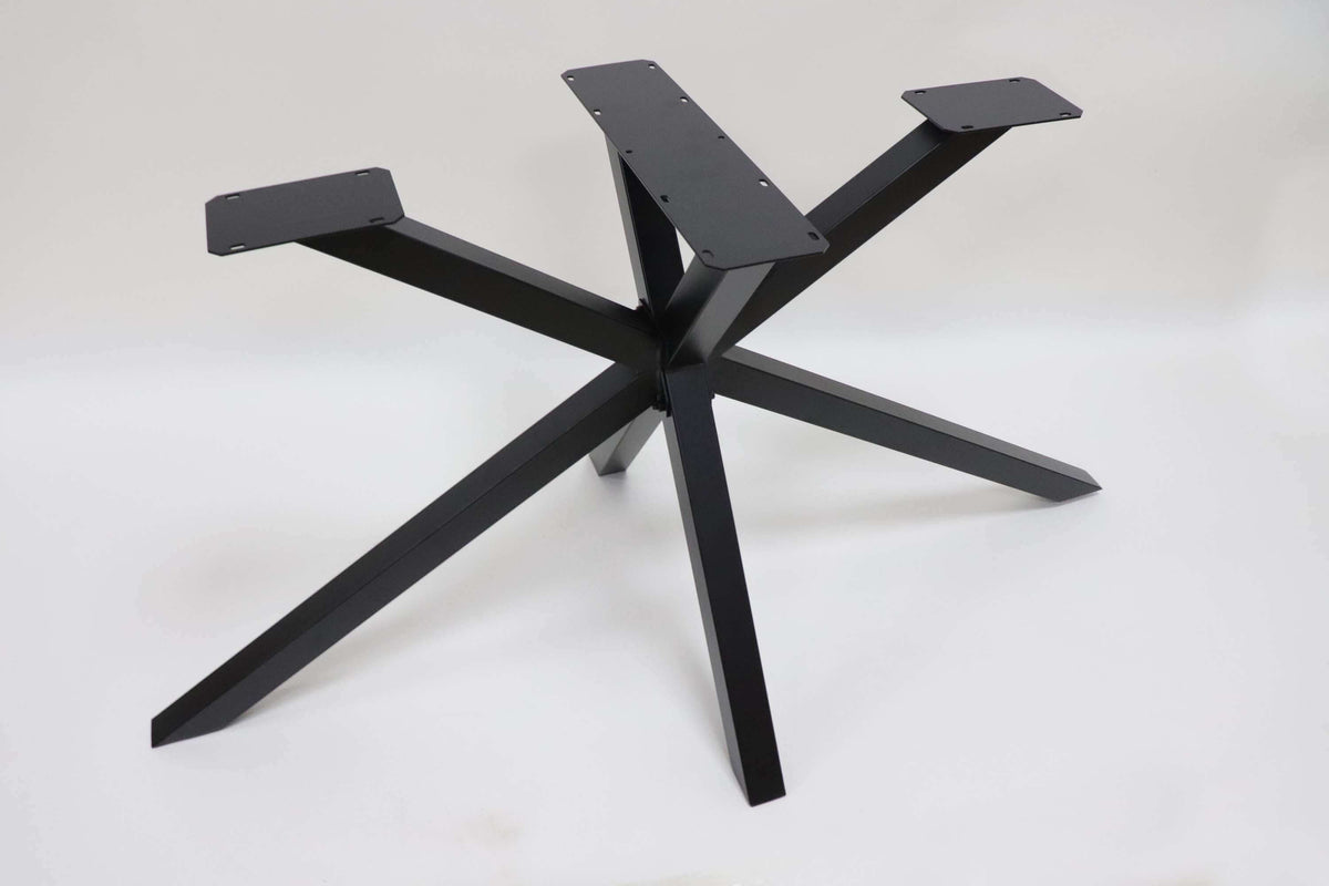 Spider dining table base with five dark metal legs and cross support plate, flat top.